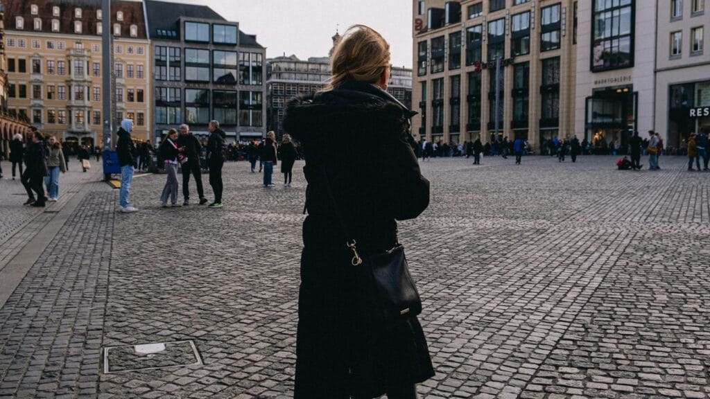 Woman takes a photo in a european city square.