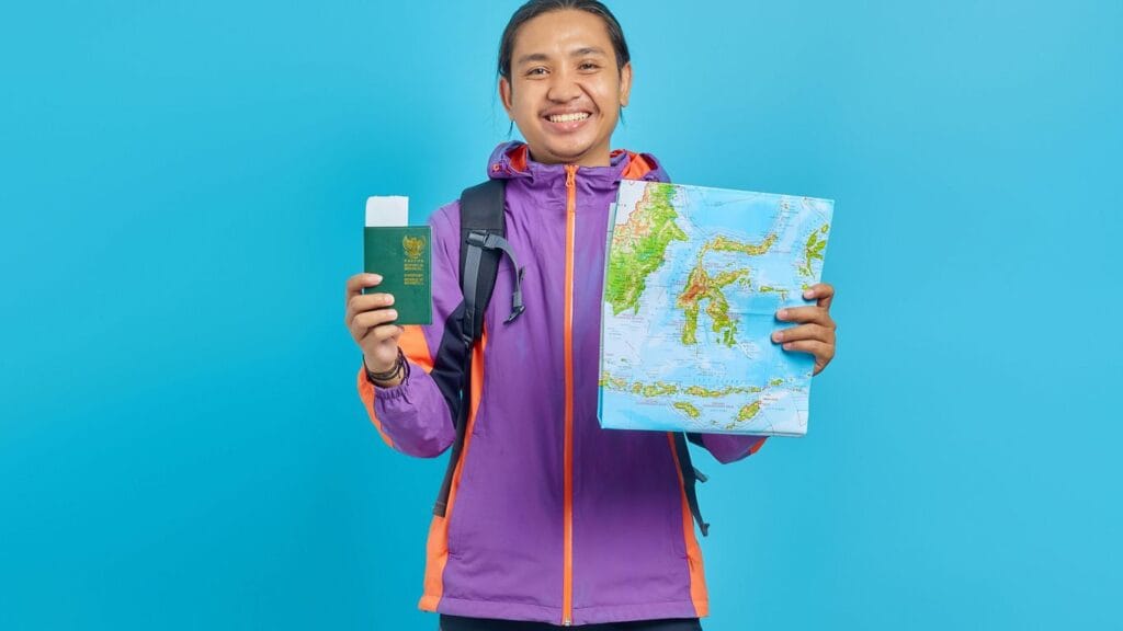 a man in a purple jacket holding a map and a passport